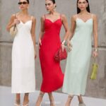 Três mulheres usando vestidos longos em cores claras e vermelho, opções de looks femininos elegantes para o Natal