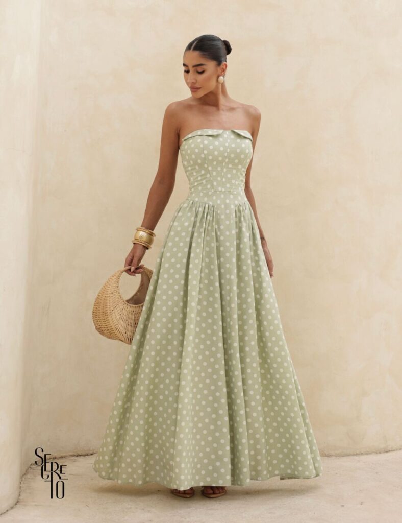 Mulher com vestido verde tomara que caia de poá, ótima inspiração de vestidos de convidadas 15 anos para eventos diurnos e sofisticados.