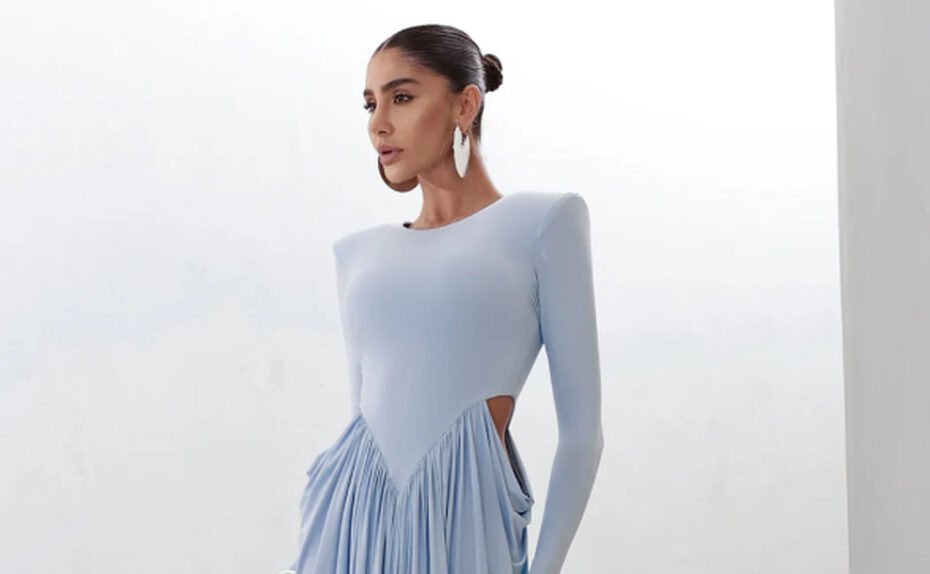 Vestido longo azul-claro com mangas compridas e saia fluida, ideal para quem busca o que vestir em um casamento no inverno.