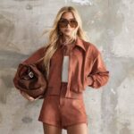Pessoa posa com conjunto moderno em tons terrosos, destacando estilo sofisticado que representa código de vestimenta casual chic elegante urbano.